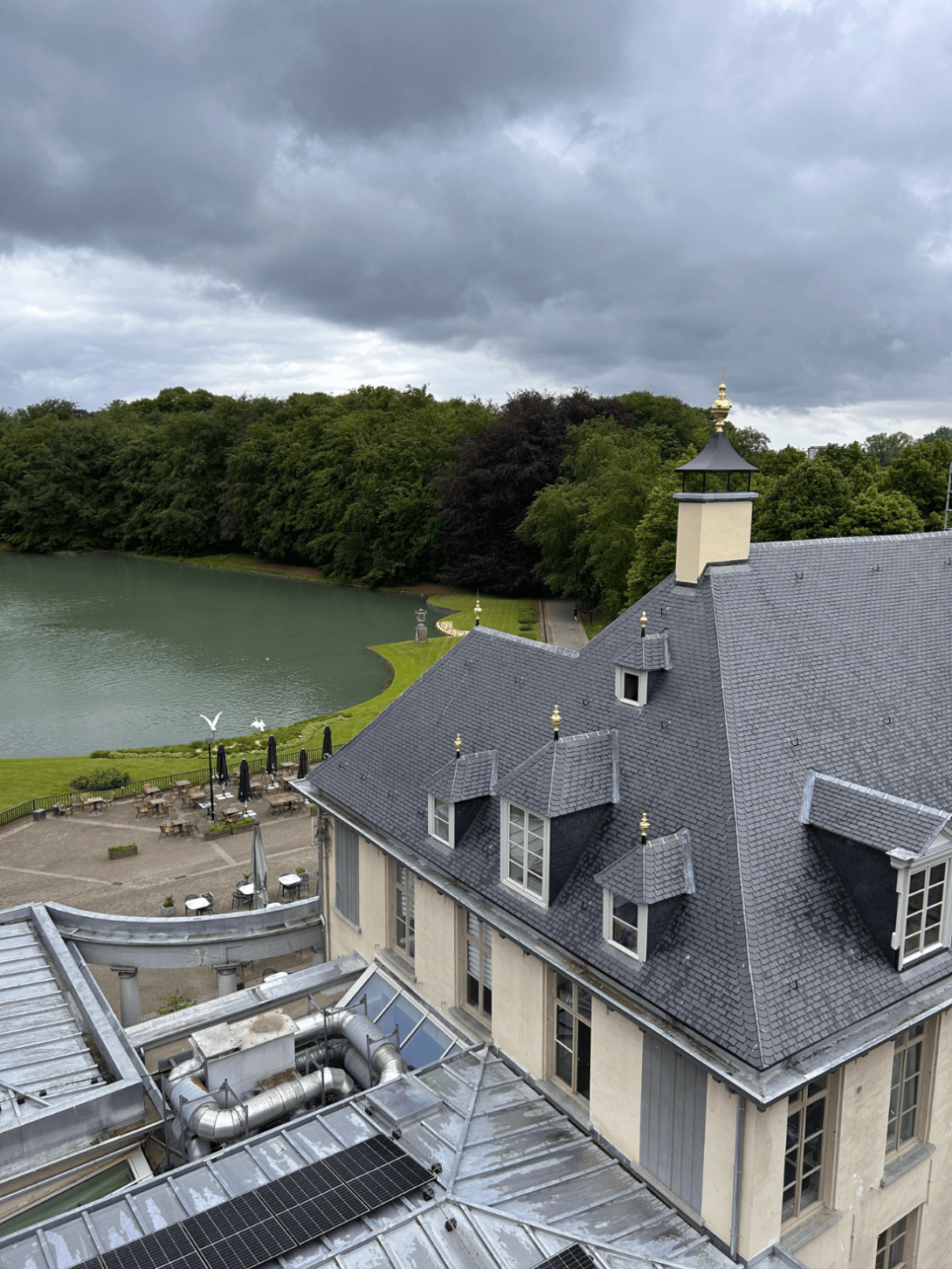Kasteel Rivierenhof met uitzicht op het dak, de vijver en het park